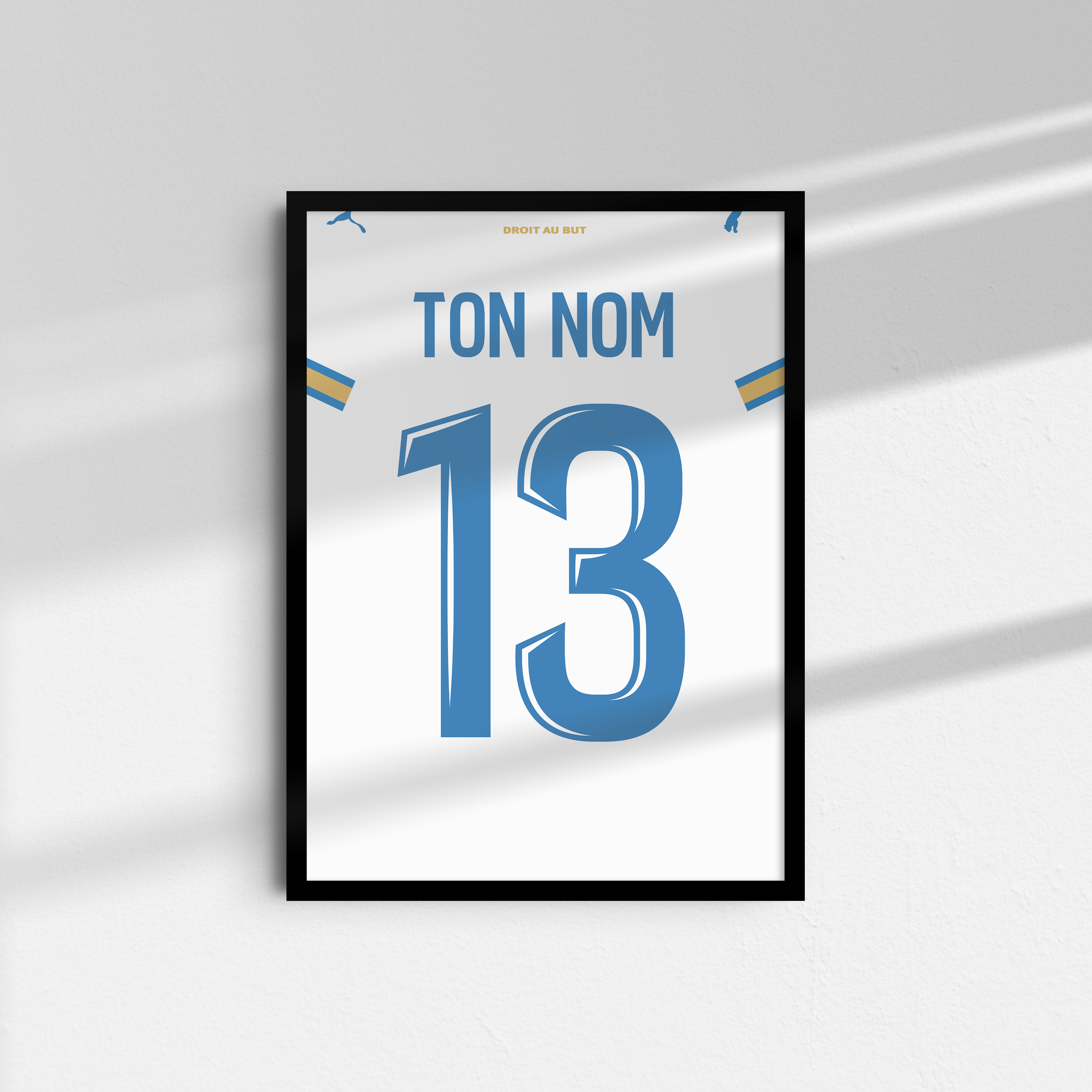 Cadre maillot OM domicile 2026-2027 personnalisé avec nom et numéro sur mur blanc